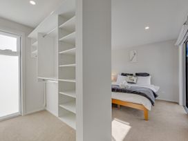 A bedroom with a bed and a closet at Sunny Deck Haven - Nelson Holiday Home in Richmond