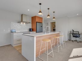 A kitchen with a countertop and bar stools at Sunny Deck Haven - Nelson Holiday Home in Richmond