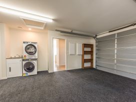 A garage with washing machine, dryer, sink and shelf at Sunny Deck Haven - Richmond