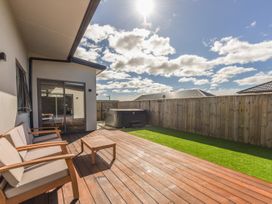 An outdoor deck with seating and a hot tub at Sunny Deck Haven - Nelson Holiday Home in Richmond