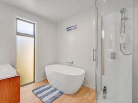 A bathroom with a bathtub and shower at Sunny Deck Haven - Nelson Holiday Home in Richmond