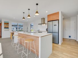 A kitchen with a refrigerator and bar stools at Sunny Deck Haven - Richmond