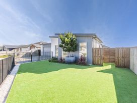 A garden with artificial grass and a plant at Sunny Deck Haven - Nelson Holiday Home, Richmond