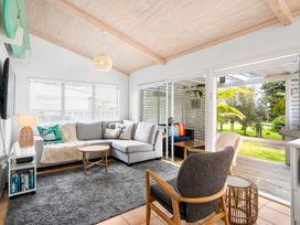 A living room with a sofa and coffee table at Slice of paradise - Whangamata Holiday Home, Whangamata