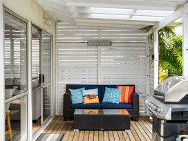 An outdoor seating area with a sofa and coffee table at Slice of paradise - Whangamata Holiday Home, Whangamata