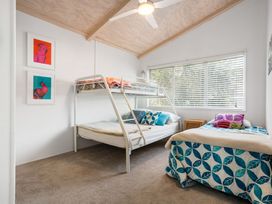 A bedroom with a bunk bed and a double bed at Slice of paradise - Whangamata Holiday Home Whangamata