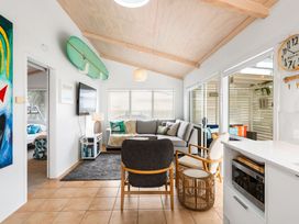 A living room with a sofa and television at Slice of paradise - Whangamata Holiday Home Whangamata