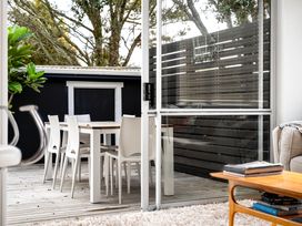 An outdoor dining area with a table and chairs at Slice of paradise - Whangamata Holiday Home in Whangamata
