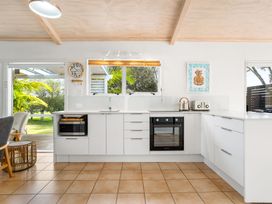A kitchen with appliances including a microwave and oven at Slice of paradise - Whangamata Holiday Home in Whangamata