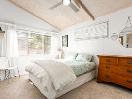 A bedroom with a bed and dresser at Slice of paradise - Whangamata Holiday Home in Whangamata