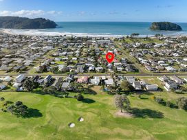 An aerial view of residential houses and a golf course at Slice of paradise - Whangamata Holiday Home, Whangamata