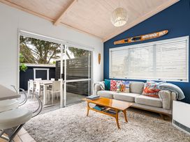 A living room with a sofa and coffee table at Slice of paradise - Whangamata Holiday Home, Whangamata