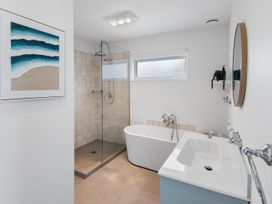 A bathroom with a bathtub and shower at Pu Corner - Waipu Holiday Home