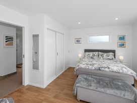 A bedroom with a bed and nightstands at Pu Corner - Waipu Holiday Home in Waipu