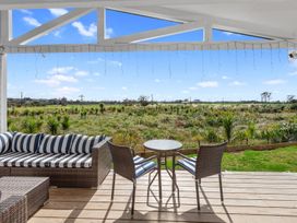 An outdoor seating area with a table and chairs at Pu Corner - Waipu Holiday Home in Waipu