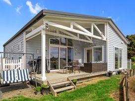 An outdoor area with seating and a swing at Pu Corner - Waipu Holiday Home Waipu