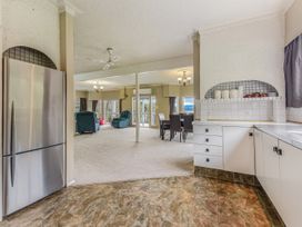 A kitchen with a refrigerator and cabinets at The Bay house - Moetapu Holiday Home