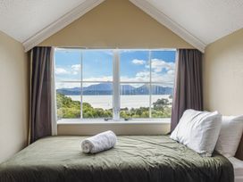 A bedroom with a bed and window overlooking mountains at The Bay house - Moetapu Holiday Home, Moetapu Bay