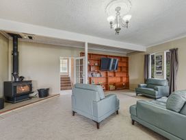 A living room with a stove and bookshelf at The Bay house - Moetapu Holiday Home Moetapu Bay