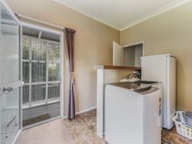 A laundry room with a washing machine and sink at The Bay house - Moetapu Holiday Home Moetapu Bay