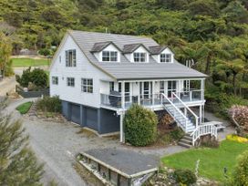 A house with a deck and garden at The Bay house - Moetapu Holiday Home in Moetapu Bay