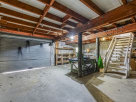 A garage with metal door and stairs at The Bay house - Moetapu Holiday Home in Moetapu Bay