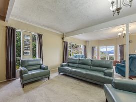 A living room with sofas and windows at The Bay house - Moetapu Holiday Home