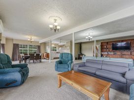 A living room with sofas and a television at The Bay house - Moetapu Holiday Home Moetapu Bay