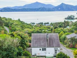 A house with a view of water and mountains at The Bay house - Moetapu Holiday Home Moetapu Bay