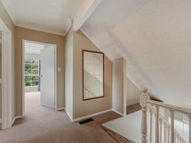 A hallway with a staircase and a mirror at The Bay house - Moetapu Holiday Home Moetapu Bay