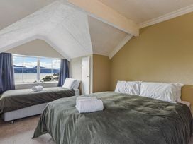 A bedroom with two beds and a window view at The Bay house - Moetapu Holiday Home Moetapu Bay