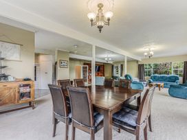 A dining area with a table and chairs in The Bay house - Moetapu Holiday Home Moetapu Bay