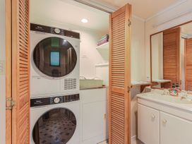A laundry room with a washer and dryer at Treetops & Tide Cottage - Moetapu Bay