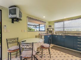 A kitchen with a table and chairs at Treetops & Tide Cottage - Moetapu Bay
