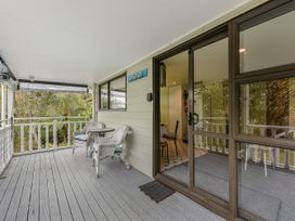 An outdoor area with a table and chairs at Treetops & Tide Cottage - Moetapu Bay