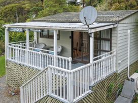An outdoor area with a veranda and furniture at Treetops & Tide Cottage - Moetapu Bay