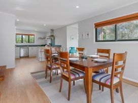 A dining room with a wooden table and chairs at Garden Grove - Kapiti Coast Holiday Home, Kapiti Coast