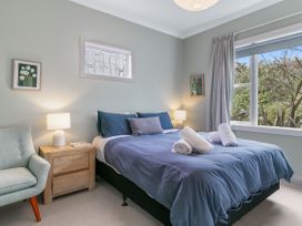 A bedroom with a bed and nightstand at Garden Grove - Kapiti Coast Holiday Home, Kapiti Coast