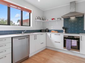 A kitchen with a sink, oven, and dishwasher at Garden Grove - Kapiti Coast Holiday Home in Kapiti Coast