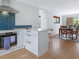 A kitchen with oven and dining area at Garden Grove - Kapiti Coast Holiday Home, Kapiti Coast
