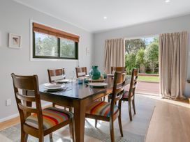 A dining room with a table set and view of the garden at Garden Grove - Kapiti Coast Holiday Home in Kapiti Coast