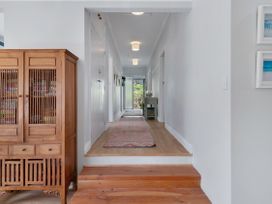 A hallway with a sideboard and rug at Garden Grove - Kapiti Coast Holiday Home