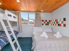 A bedroom with a bunk bed and a double bed at Garden Grove - Kapiti Coast Holiday Home in Kapiti Coast