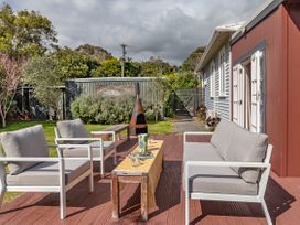 An outdoor seating area with chairs and a table at Garden Grove - Kapiti Coast Holiday Home, Kapiti Coast