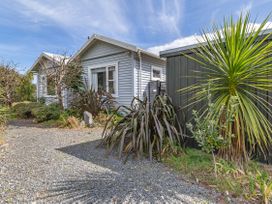 A house with plants and a gravel path at Garden Grove - Kapiti Coast Holiday Home in Kapiti Coast