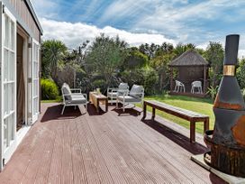 An outdoor seating area with a gazebo and seating at Garden Grove - Kapiti Coast Holiday Home