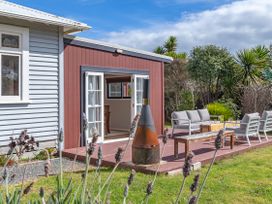 An outdoor patio with seating and a fire pit at Garden Grove - Kapiti Coast Holiday Home, Kapiti Coast