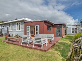 A house with a deck and outdoor seating at Garden Grove - Kapiti Coast Holiday Home Kapiti Coast