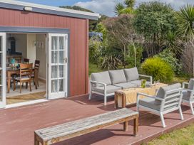 An outdoor seating area with a table and chairs at Garden Grove - Kapiti Coast Holiday Home Kapiti Coast