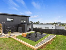 An outdoor area with weightlifting equipment and a storage shed at Langs Life - Waipu Holiday Home Waipu Cove